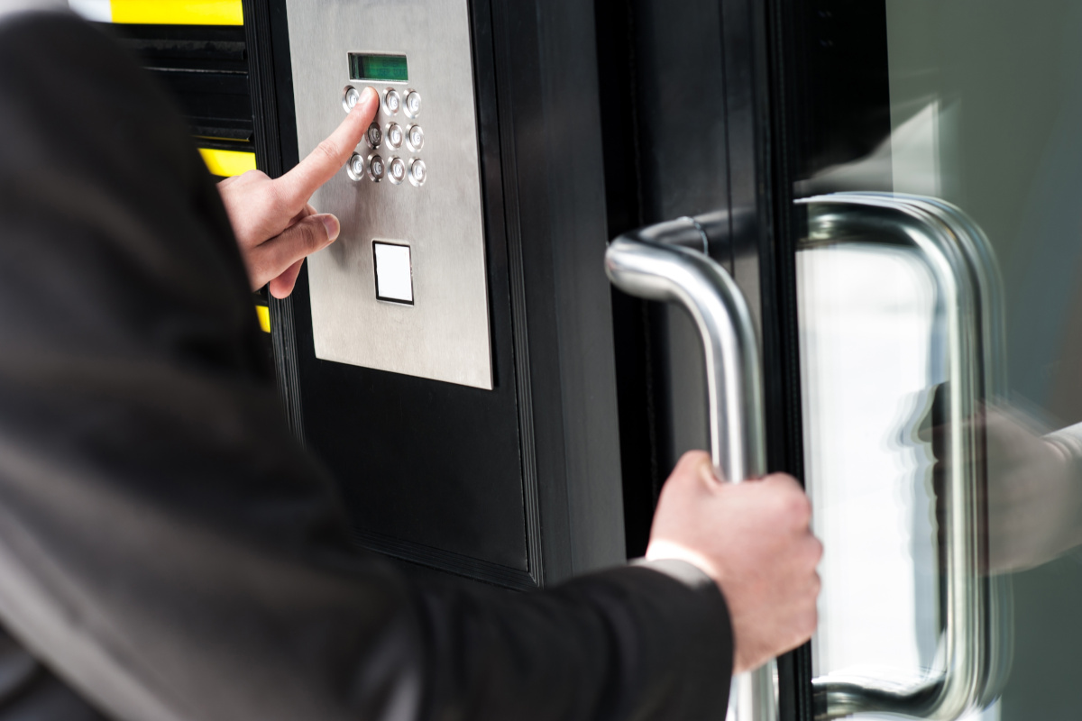 A person trying to unlock a door with access control systems installed