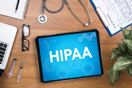 Tablet in a doctors office displaying the word 'HIPAA'