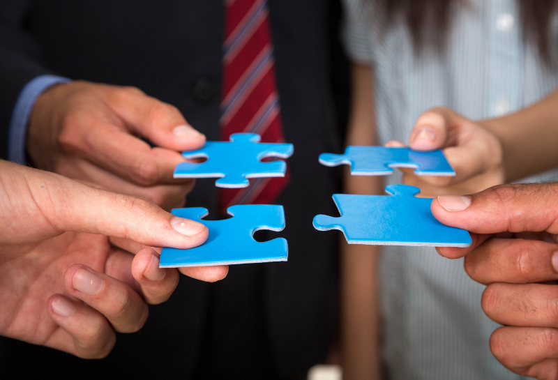 Business People Holding Puzzle Pieces