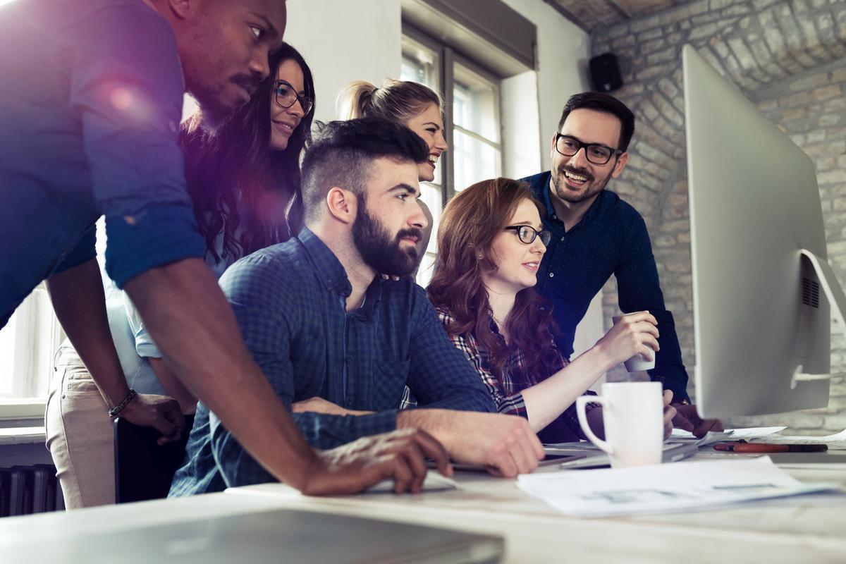 Group of young business people looking at something on computer