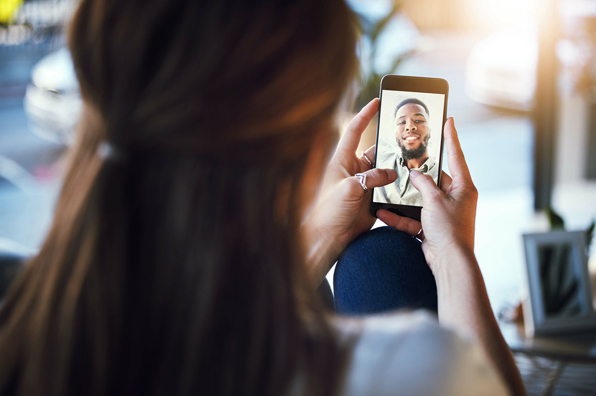Over the shoulder view of a woman holding up a smartphone for a video call
